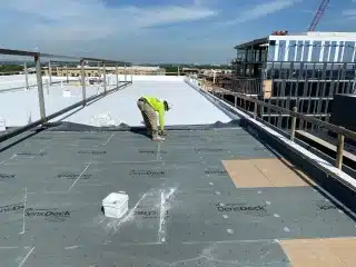 worker screwing on roof 